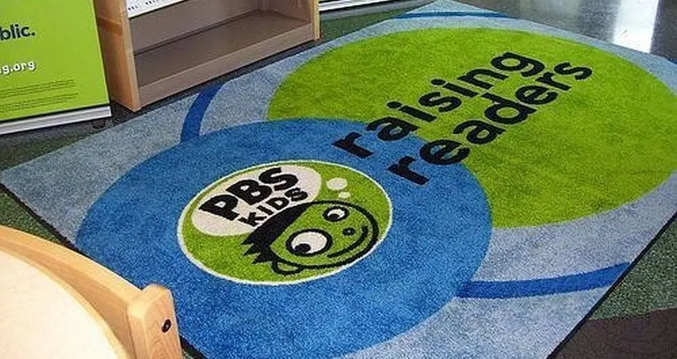 Close-up of a printed DigiPrint HD custom logo mat by Rug Rats showing full-color photographic logo detail