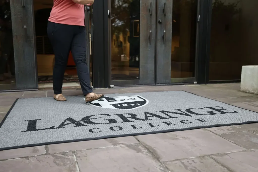 Gray WaterHog Impressions entrance mat with LaGrange College shield and wordmark at an exterior campus building entrance